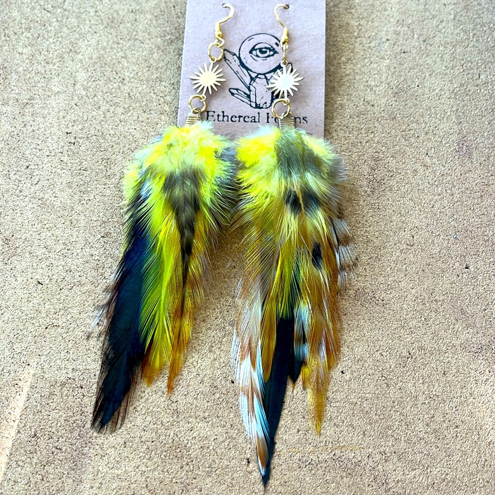 Long yellow feather earrings with gold star sun pendants